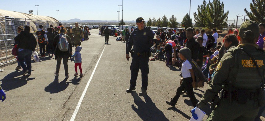 This May 29, 2019, photo released by U.S. Customs and Border Protection (CBP) shows some of 1,036 migrants who crossed the U.S.-Mexico border in El Paso, Texas, the largest that the Border Patrol says it has ever encountered.