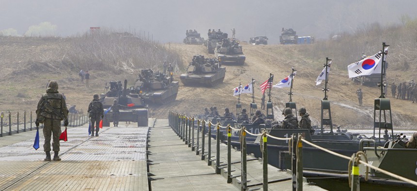 U.S. soldiers drive Abrams tanks and Bradley Infantry Fighting Vehicles across South Korea's Imjin River on a bridge assembled by Republic of Korea Army engineers in 2016.
