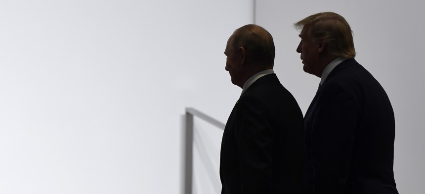 President Donald Trump and Russian President Vladimir Putin walk to participate in a group photo at the G20 summit in Osaka, Japan, Friday, June 28, 2019.