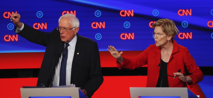 Sen. Bernie Sanders, I-Vt., and Sen. Elizabeth Warren, D-Mass., talk during in the first of two Democratic presidential primary debates hosted by CNN Tuesday, July 30, 2019, in the Fox Theatre in Detroit.