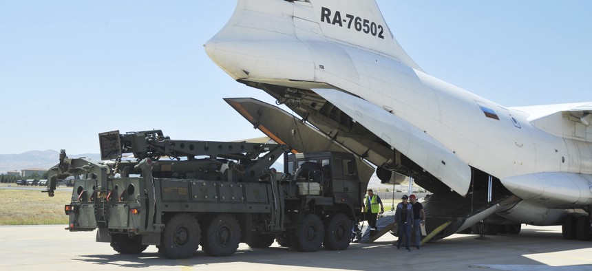 Military officials work around a Russian transport aircraft carrying parts of the S-400 air defense systems, after it landed at Murted military airport outside Ankara on Aug. 27..