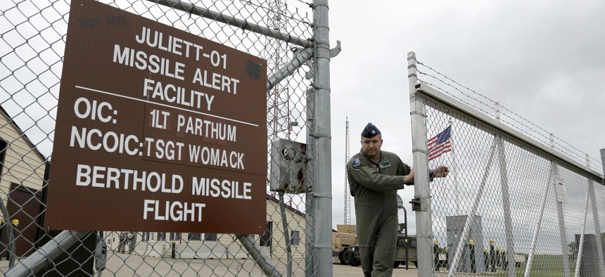 An airman closes the gate at an ICBM launch control facility outside Minot, N.D.