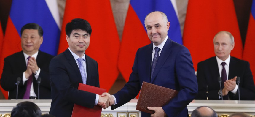 Deputy Chairman of Huawei Guo Ping shakes hands with Alexei Kornya, president of Russia's MTS mobile network operator, at the Kremlin in Moscow on June 5, 2019, as Russian President Vladimir Putin and Chinese President Xi Jinping look on.