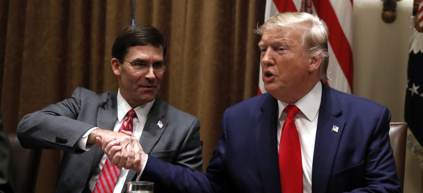 President Donald Trump shakes hands with Defense Secretary Mark Esper during a briefing with senior military leaders in the Cabinet Room at the White House in Washington, Monday, Oct. 7, 2019