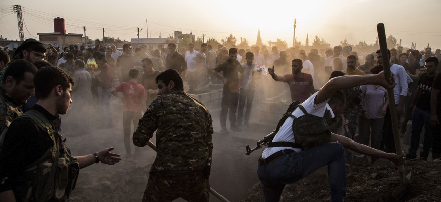Syrians bury Syrian Democratic Forces fighters killed fighting Turkish advance in the Syrian town of Qamishli, Saturday, Oct. 12, 2019,