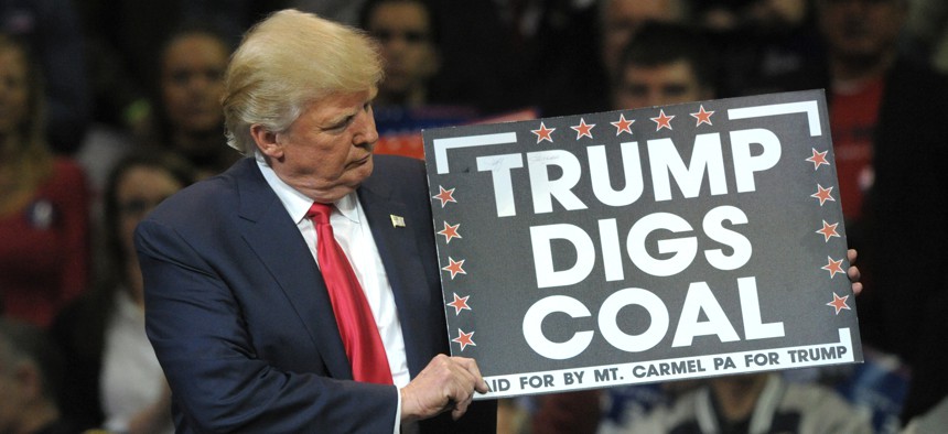 Republican Presidential nominee Donald Trump holds a 'Trump Digs Coal' sign during a rally Oct. 10, 2016, at Mohegan Sun Arena in Wilkes-Barre, Pennsylvania