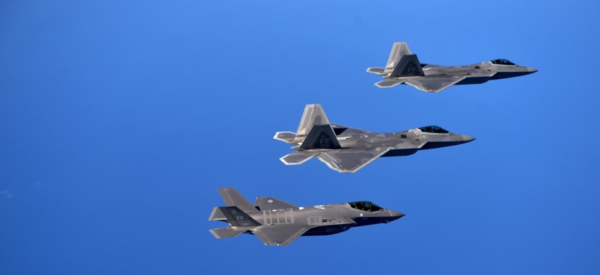 F-22 Raptors from the 94th Fighter Squadron, Joint Base Langley-Eustis, Virginia, and F-35A Lightning IIs from the 58th Fighter Squadron, Eglin Air Force Base, Florida, over the Eglin Training Range, Florida, Nov. 5, 2014.
