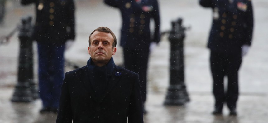 French President Emmanuel Macron stand at attention at the Arc de Triomphe during commemorations marking the 101st anniversary of the 1918 armistice.