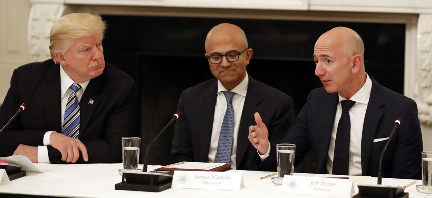 In this June 19, 2017, file photo President Donald Trump, left, and Satya Nadella, Chief Executive Officer of Microsoft, center, listen as Jeff Bezos, Chief Executive Officer of Amazon, speaks during an American Technology Council roundtable.