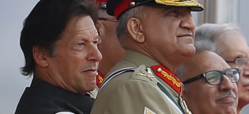In this March 23, 2019 photo, Pakistan's Army Chief Gen. Qamar Javed Bajwa, center, watches a parade with Prime Minister Imran Khan, left, and President Arif Alvi, in Islamabad, Pakistan.