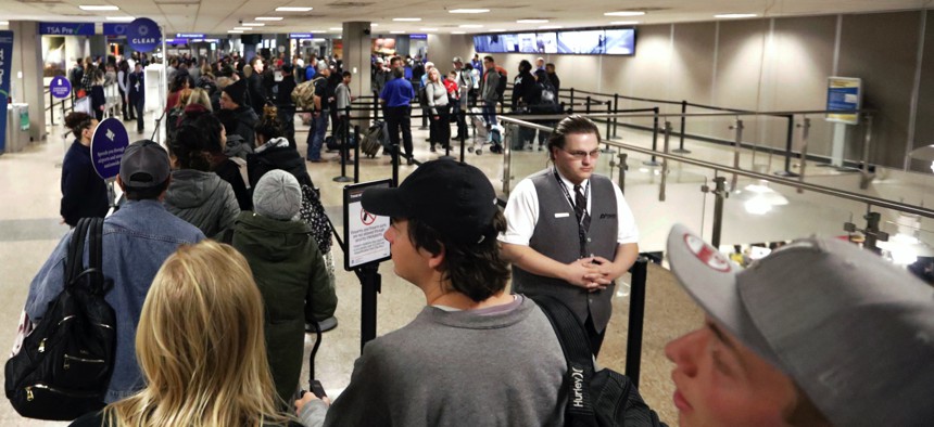  In this Wednesday, Nov. 27, 2019, file photo, travelers walk through a security checkpoint in Terminal 2 at Salt Lake City International Airport, in Salt Lake City. 