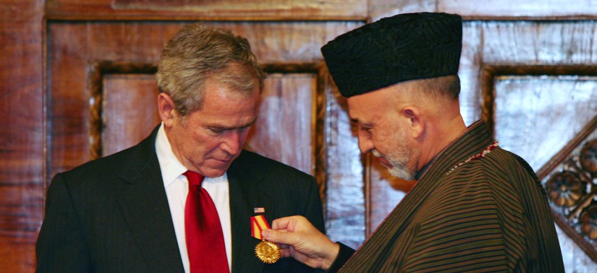 Afghan President Hamid Karzai, right, gives a medal to U.S. President George W. Bush at the presidential palace in Kabul, Afghanistan on Monday, Dec. 15, 2008.Afghan President Hamid Karzai, right, gives a medal to U.S. President George W. Bush at the pres