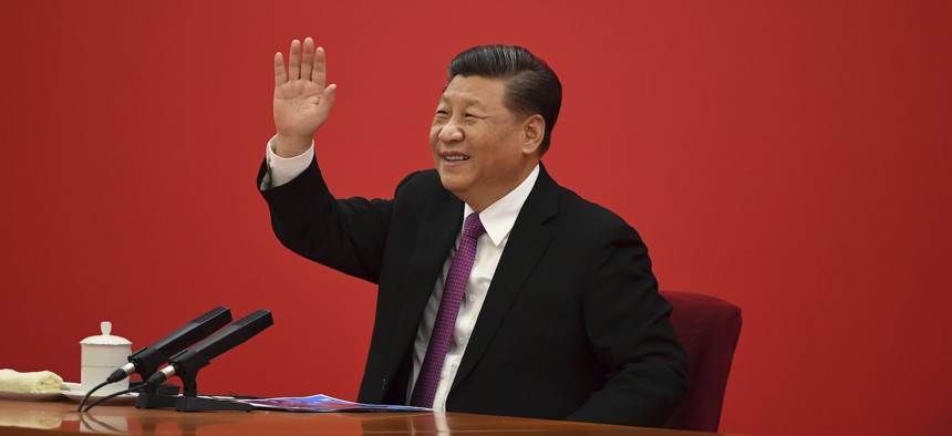 China's President Xi Jinping waves to Russian President Vladimir Putin via a video link, from the Great Hall of the People in Beijing, Monday, Dec. 2, 2019.