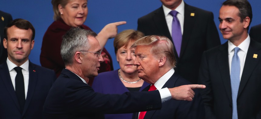 NATO Secretary General Jens Stoltenberg, center front left, speaks with U.S. President Donald Trump, center front right, after a group photo at a NATO leaders meeting in England, Wednesday, Dec. 4, 2019. 