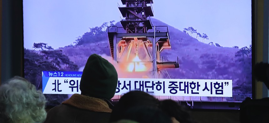People watch a TV screen at the Seoul Railway Station in Seoul, South Korea, on Dec. 9, 2019. North Korea said Sunday it carried out a "very important test" at its long-range rocket launch site. The sign reads: "Very important test." 