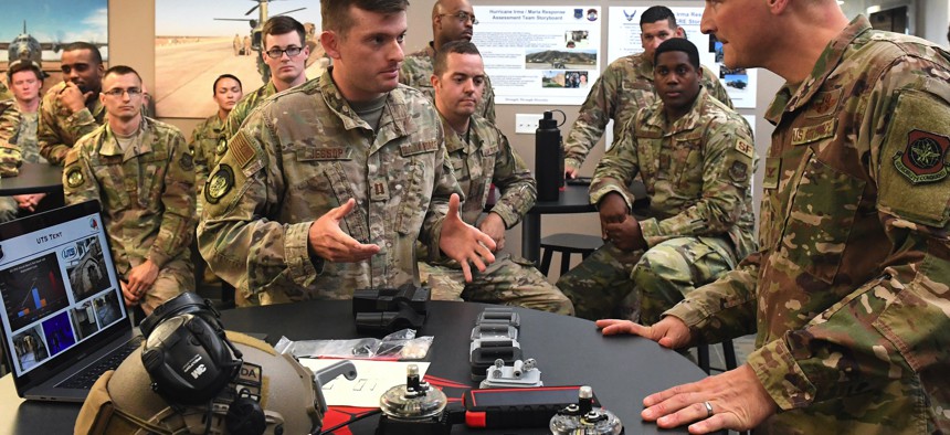 Capt. Alex Jessop, 821st Contingency Response Squadron, , shows a 3D printed adapter to a Phantom brand tactical airfield lights to Col. Douglas Jackson, 621st Contingency Response Wing commander, during Jackson's immersion tour June 24, 2019.