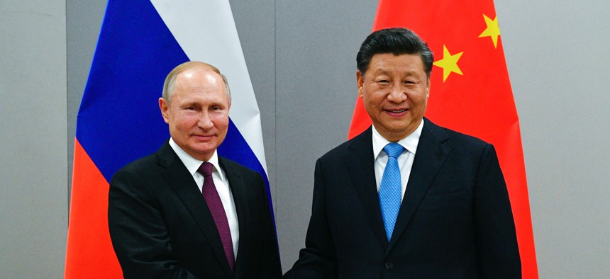 Russian President Vladimir Putin, left, and China's President Xi Jinping shake hands prior to their talks on the sideline of the 11th edition of the BRICS Summit, in Brasilia, Brazil, Wednesday, Nov. 13, 2019.