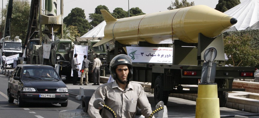 Iranians drive next to a Shahab-3 ballistic missile, which is displayed in an equipment display by the Iranian Revolutionary Guard marking the 30th anniversary of the outset of the1980-88 Iran-Iraq war, at Baharestan Square in Tehran, Iran, in 2010.