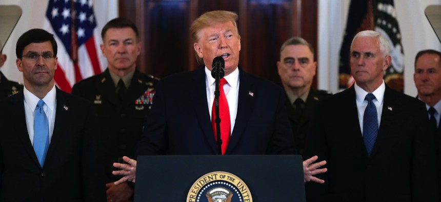 President Donald Trump addresses the nation from the White House on the ballistic missile strike that Iran launched against Iraqi air bases housing U.S. troops, Wednesday, Jan. 8, 2020, in Washington, as Vice President Mike Pence and others look on.