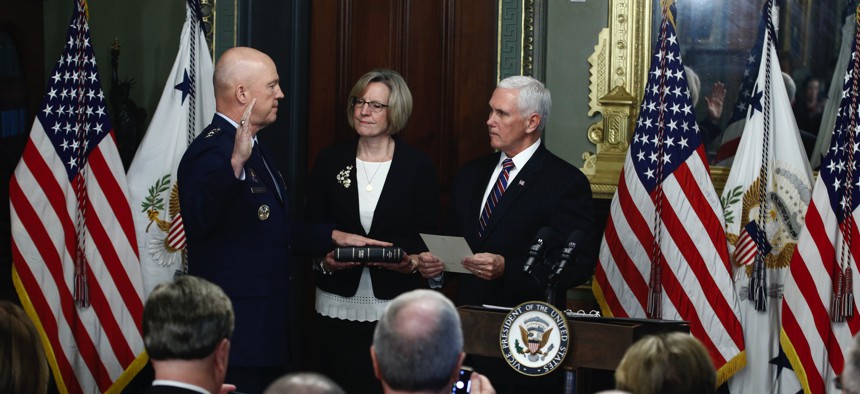 Vice President Mike Pence, right, swears in Air Force General John Raymond as Chief of Space Operations, as his wife, Molly, center, holds a bible in the Ceremonial office at the Executive Office Building, Tuesday, Jan. 14, 2020, in Washington. 