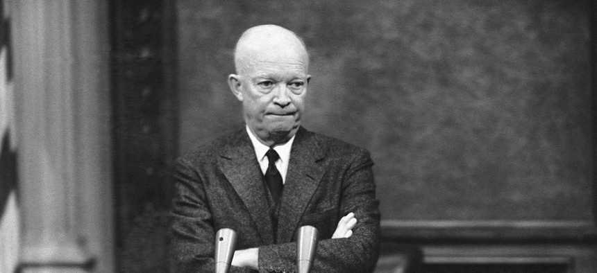 President Dwight Eisenhower, tight- lipped and standing with folded arms, is thoughtful in Washington, D.C., Jan. 19, 1956.