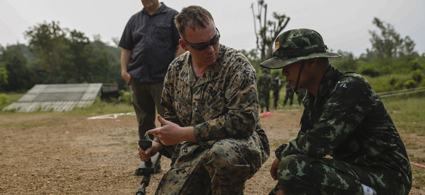 U.S. Marine Corps Staff Sgt. Gabriel T. Green, a platoon sergeant with 9th assists Thai soldiers with a metal detector during survey training event at the Charumanee Training Field in Ratchaburi, Kingdom of Thailand, Dec. 18, 2018. 