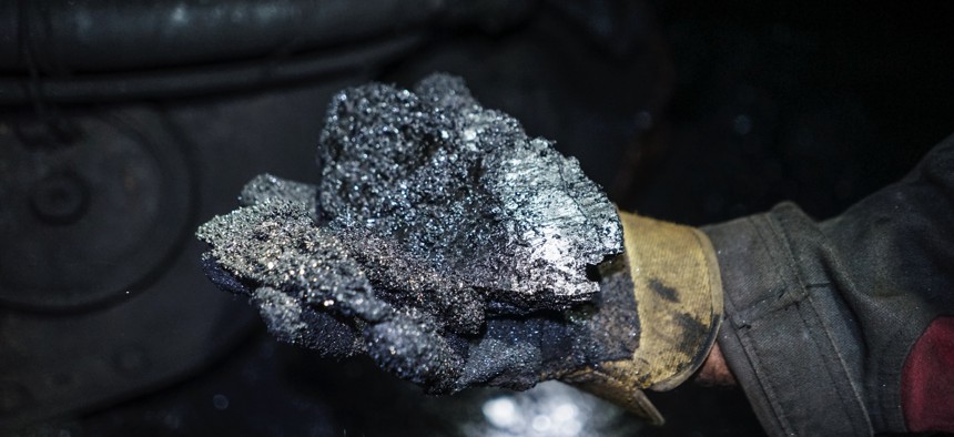 In this 2015 photo, a miner shows a lump of coal at one of the Krasnodonugol coal mines in Krasnodon, eastern Ukraine.