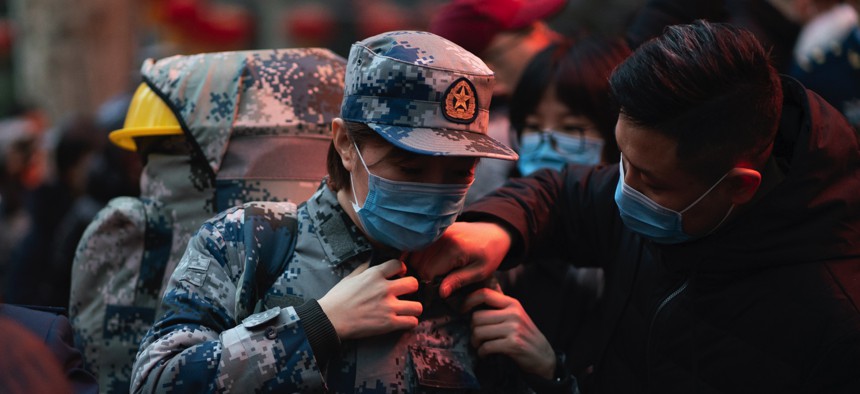 In this photo taken January 24, 2020 and released by Xinhua News Agency, a military medic from the Air Force Medical University prepares to leave for Wuhan from Xi'an, capital of northwestern China's Shaanxi Province.