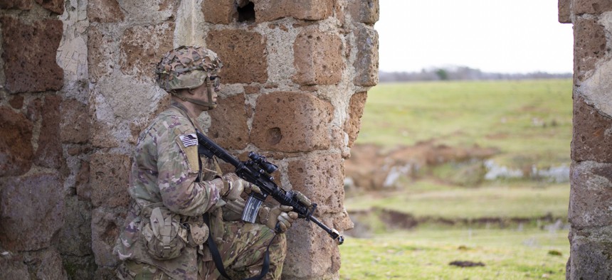 A U.S. Army paratrooper simulates providing security during a mock airborne assault in Monte Romano, Italy, Jan. 29, 2020.