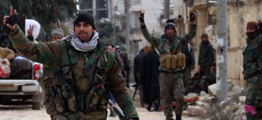 Syrian soldiers flash the victory sign in the Rashideen neighborhood, in Aleppo province, Syria, in this photo released Sunday, Feb. 16, 2020.