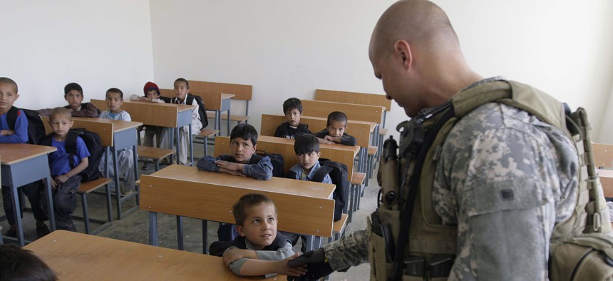 A US soldier of Combined Joint Special Operations Task Force Afghanistan shakes hand with an Afghan boy during the opening of a school in Bagram, north of Kabul, Afghanistan, Monday, March 24, 2008. 