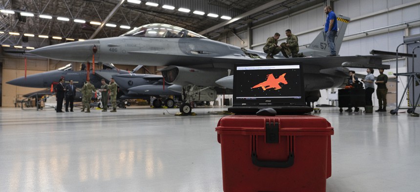 A completed 3-D scan of a F-16C Fighting Falcon is displayed on a screen as technicians maintain at Nellis Air Force Base, Nevada, Feb. 11, 2020. Operators looked to recreate the jet using virtual reality