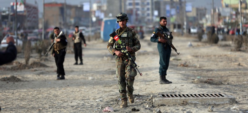 Afghan security personnel gather at the site of bomb explosion in Kabul, Afghanistan, Wednesday, Feb. 26, 2020.