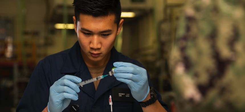 Navy Seaman Kenny Liu prepares a needle with a flu vaccination aboard the USS Gerald R. Ford in Newport News, Va., Oct. 22, 2019. The ship’s crew received flu vaccines.
