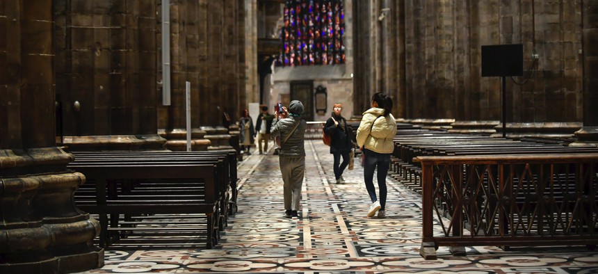 Tourists walk in the Duomo gothic cathedral after it was reopened following a closure due to the COVID-19 virus outbreak in northern Italy, in Milan, Monday, March 2, 2020. 