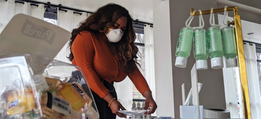 Adilisha Patrom, owner of a co-working and event space next to Gallaudet University, organizes face masks, hand sanitizer and other supplies inside her pop up shop on Thursday, March 5, 2020, in Washington, D.C.