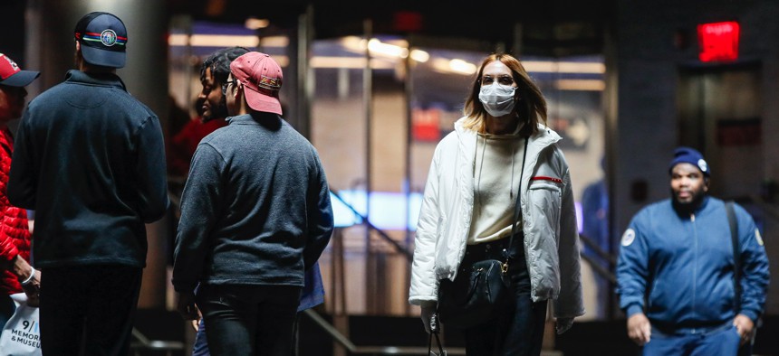 A commuter wears a face mask in the New York City transit system, Monday, March 9, 2020, in New York. New York continued grappling Monday with the new coronavirus, as case numbers, school closings and other consequences grew.