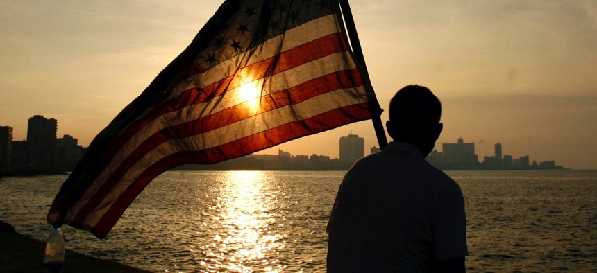 A Mexican-American, studying medical science in a Cuban university holds a U.S flag as he watches the sunset in Havana after a march to commemorate the 136th anniversary of the execution of eight students by the Spanish colonial government in 2007.