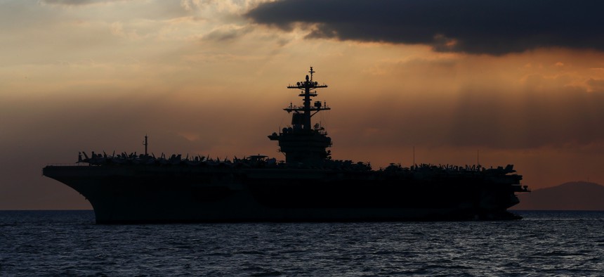 In this April 13, 2018, file photo the USS Theodore Roosevelt aircraft carrier is anchored off Manila Bay west of Manila, Philippines