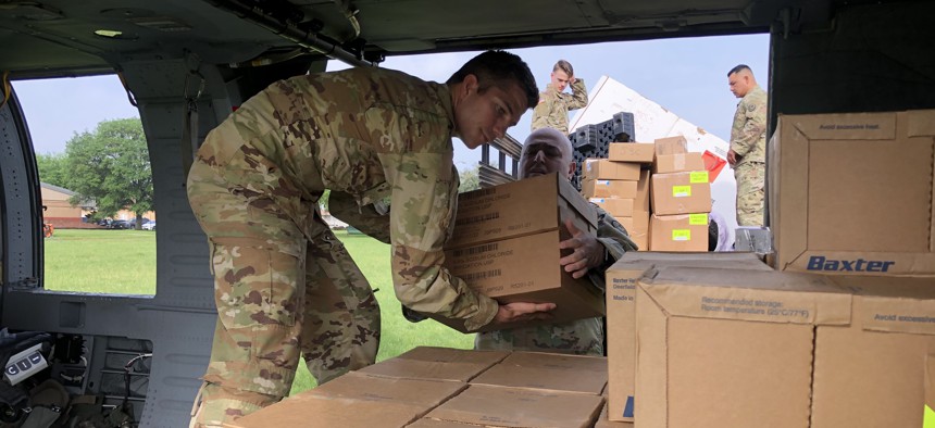 exas Army National Guard Soldiers load a UH-60 Black Hawk at Camp Mabry on April 8, 2020 with personal protective equipment for distribution in La Marque, Texas. 