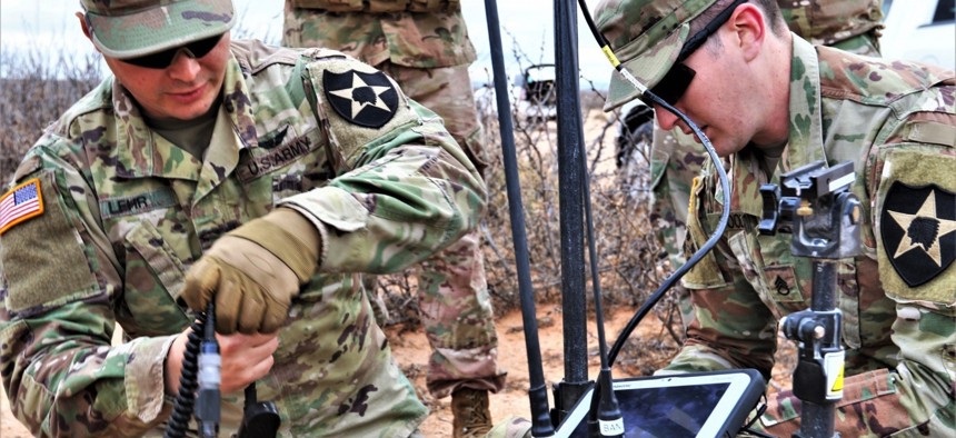 Staff Sgt. Christian Lehr and Staff Sgt. Trever Cooley, electronic warfare specialist with 2nd Brigade, 2nd Infantry Regiment, set up their portable packs which have capabilities of picking up and jamming enemy frequencies.