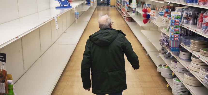 A shopper looks for toilet paper at a Stop & Shop supermarket during hours open daily only for seniors Thursday, March 19, 2020, in North Providence, R.I.