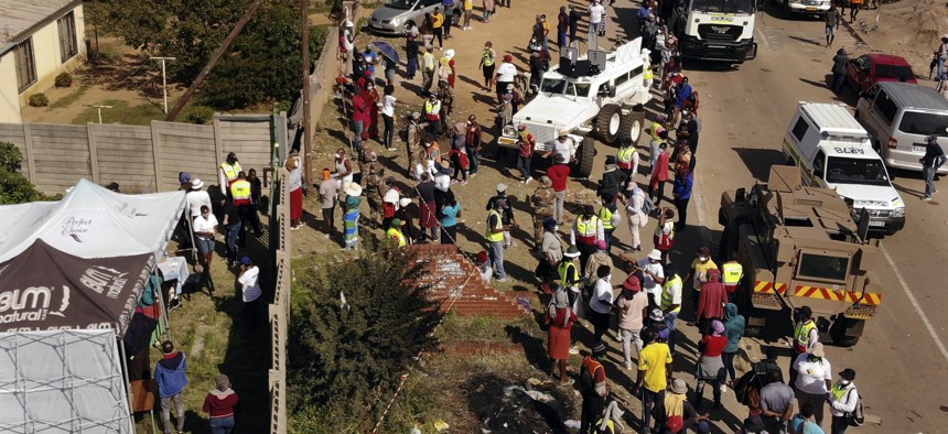 Thousands line up to receive food handouts in the Olievenhoutbos township of Midrand, South Africa, Saturday May 2, 2020. though South Africa begun a phased easing of its strict lockdown measures on May 1