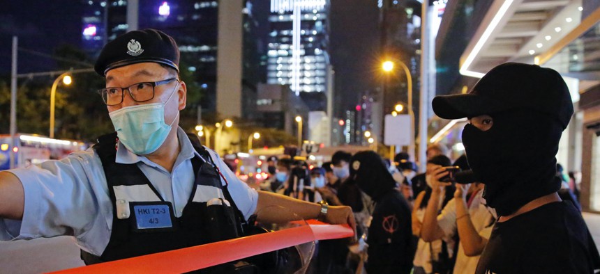 Police officers put up a cordon line in front of the protesters during a protest in Hong Kong, Friday, May 15, 2020.