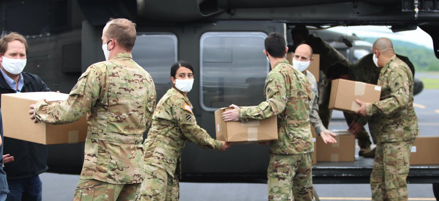 D.C. National Guard soldiers pass boxes of medical face masks to be loaded on a UH-60 Black Hawk helicopter during an aeromedical support mission in Asheboro, N.C., April 25, 2020.