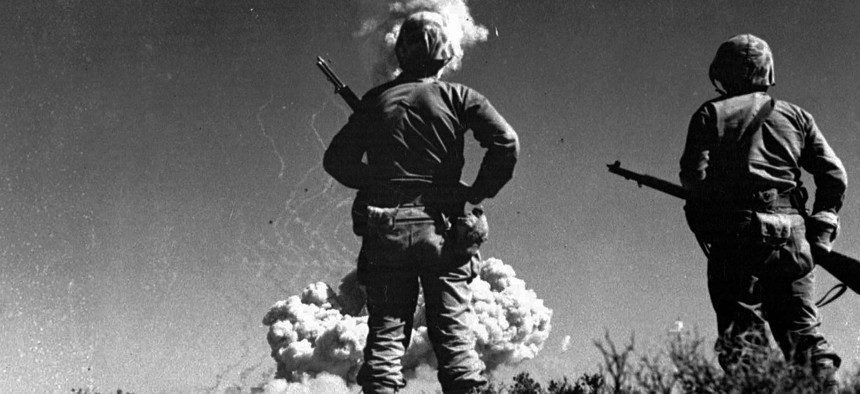 Two soldiers look at an atomic cloud during a nuclear bomb testing in Nevada in this 1952 file photo.
