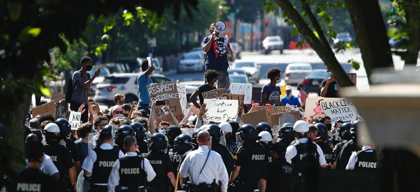 Protesters gather in front of a line of Uniformed U.S. Secret Service as demonstrators gather to protest the death of George Floyd, near the White House, Saturday, May 30, 2020, in Washington. 