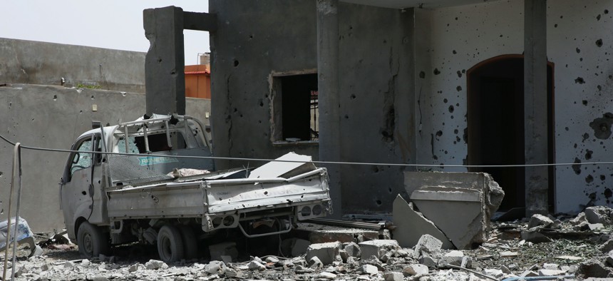 In this June 15, 2019, file photo, a vehicle and structure is damaged from fighting in the region of Tajoura, east of the Libyan capital Tripoli. 