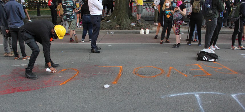 Protesters paint "Revolution" on a sidewalk in front of the White House, June 2, 2020.