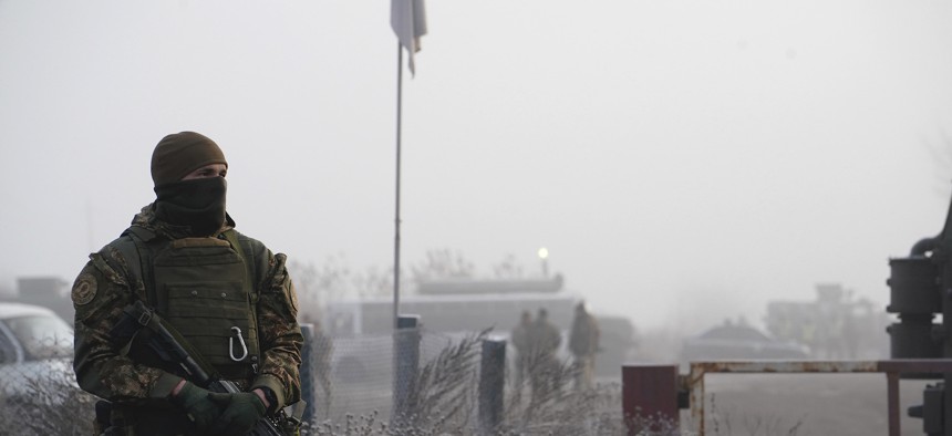 A Ukrainian soldier guards an area during war prisoners exchange near Odradivka, eastern Ukraine, Sunday, Dec. 29, 2019. 